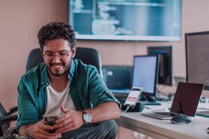 A programmer diligently testing smartphone applications while sitting in their office. photo