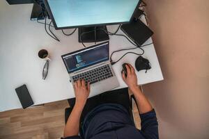 Top view of programmer diligently testing smartphone applications while sitting in their office. photo