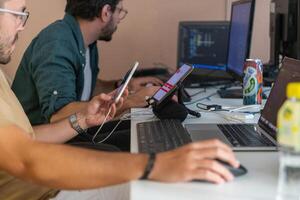 Programmers engrossed in deep collaboration, diligently working together to solve complex problems and develop innovative mobile applications with seamless functionality. photo
