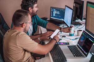 Programmers engrossed in deep collaboration, diligently working together to solve complex problems and develop innovative mobile applications with seamless functionality. photo