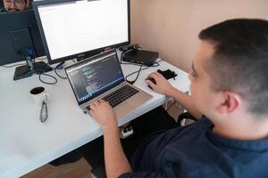 A programmer diligently testing smartphone applications while sitting in their office. photo