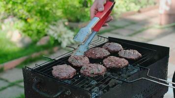 Person cooking hamburgers meat on grill. BBQ, cookout concept. video