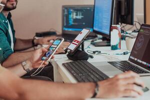 Programmers engrossed in deep collaboration, diligently working together to solve complex problems and develop innovative mobile applications with seamless functionality. photo