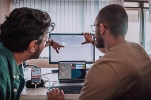Programmers engrossed in deep collaboration, diligently working together to solve complex problems and develop innovative mobile applications with seamless functionality. photo