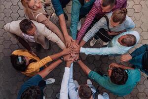 Top view photo of a group of business people and colleagues standing together holding hands, looking towards the camera, symbolizing unity and teamwork.