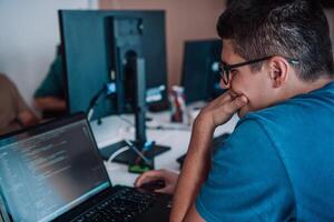 A programmer diligently testing smartphone applications while sitting in their office. photo