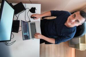 Top view of programmer diligently testing smartphone applications while sitting in their office. photo