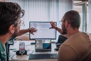 Programmers engrossed in deep collaboration, diligently working together to solve complex problems and develop innovative mobile applications with seamless functionality. photo