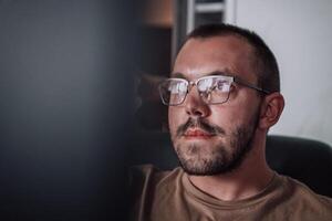 A programmer diligently testing smartphone applications while sitting in their office. photo