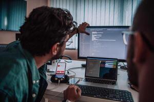 Programmers engrossed in deep collaboration, diligently working together to solve complex problems and develop innovative mobile applications with seamless functionality. photo