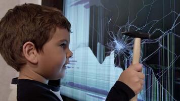 The Handyman in Training. A Young Boy with a Hammer Fixes a Broken Screen TV video