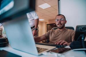 A programmer diligently testing smartphone applications while sitting in their office. photo