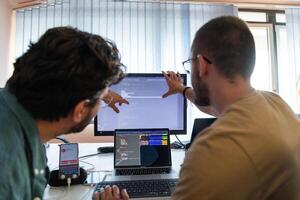Programmers engrossed in deep collaboration, diligently working together to solve complex problems and develop innovative mobile applications with seamless functionality. photo