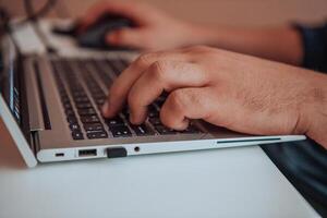 Close-up photo of a programmer typing on a laptop