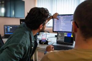Programmers engrossed in deep collaboration, diligently working together to solve complex problems and develop innovative mobile applications with seamless functionality. photo