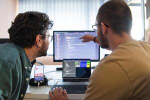 Programmers engrossed in deep collaboration, diligently working together to solve complex problems and develop innovative mobile applications with seamless functionality. photo
