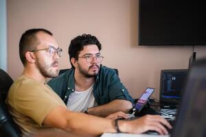 Programmers engrossed in deep collaboration, diligently working together to solve complex problems and develop innovative mobile applications with seamless functionality. photo