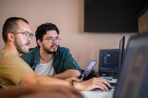 Programmers engrossed in deep collaboration, diligently working together to solve complex problems and develop innovative mobile applications with seamless functionality. photo