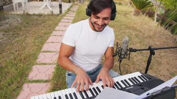 Smiling Boy Plays And Sing The Keyboard In The Park Outside With Headphones video