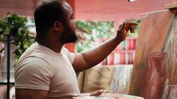 Artist applies watercolor paints on a canvas with a paintbrush, creating a stunning piece of fine art. Painter uses vibrant colors and dynamic brushstrokes effects as leisure activity. Camera A. video