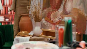 Empty art and craft workshop with a rustic beautiful painting on canvas, creative work with watercolor paint in a modern contemporary atelier. Artistic masterpiece with paint tubes and tools. video