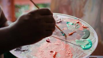 Artist mixes pigments to achieve the perfect dye shade in a workshop. Using professional art supplies to create a beautiful masterpiece on canvas, quality time in atelier. Close up. Camera B. video