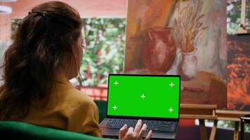 Skilled artist using chroma key mockup on display in art and craft workshop, working on multicolored masterpiece for her gallery exhibition. Proud confident woman admires her painting. Camera B. video