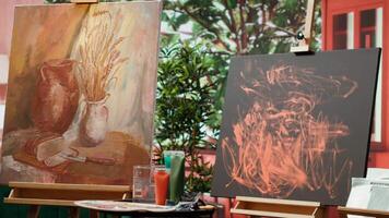 Empty art and craft workshop with a rustic beautiful painting on canvas, creative work with watercolor paint in a modern contemporary atelier. Artistic masterpiece with paint tubes and tools. video