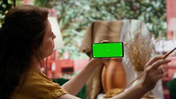 Painter holding a device with isolated mockup screen in art studio, looking at finished masterpiece with oil paints on canvas. Beautiful rustic artwork for fine art gallery, creativity. Camera A. video