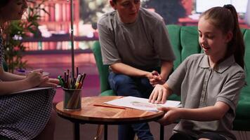Teen girl participates in a drawing activity as part of psychotherapy, helping her express feelings and intrusive thoughts. Session to overcome personal struggles through art. Camera A. video