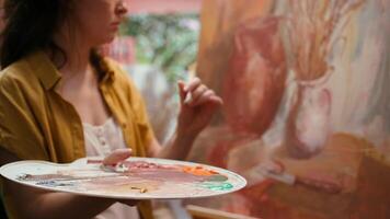 Talented artist painting artwork with colorful paints mixed on palette, creating beautiful creative paintwork with a painting technique in atelier. Painter mixing watercolor. Close up. Camera B. video