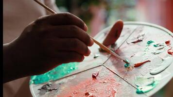 Artist mixes pigments to achieve the perfect dye shade in a workshop. Using professional art supplies to create a beautiful masterpiece on canvas, quality time in atelier. Close up. Camera A. video