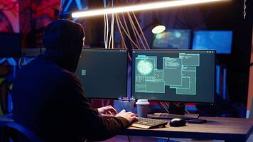 Hacker happy after successfully doing computer sabotage using encryption trojan ransomware in hidden base. Cybercriminal demands ransom money from victims after gaining access to their data, camera B video