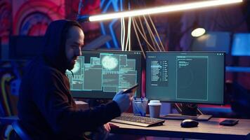 Hacker arriving in secret underground base with SSD containing data from victim after tricking it into installing ransomware program he developed. Man satisfied with his criminal plan, camera B video