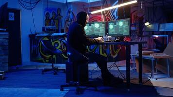 Hacker in hidden base successfully getting past anti tamper measures implemented by companies to protect products. Cracker pirating software and game releases, camera A handheld camera shot video
