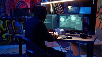 Jolly hacker in graffiti painted hideout excited after managing to steal valuable data, using phishing technique that tricks users into revealing passwords, getting access granted, zoom in shot video