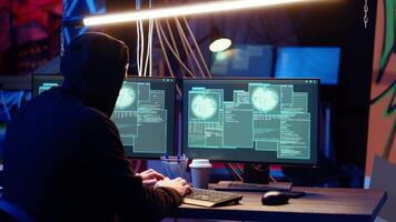 Hacker in hidden base successfully getting past anti tamper measures implemented by companies to protect products. Cracker pirating software and game releases, camera B video