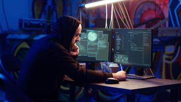 Malicious man hacking and talking on phone with partner, stealing credit card numbers, manipulating banking systems. Evil hacker runs dangerous code, chatting with friend in telephone call, camera B video