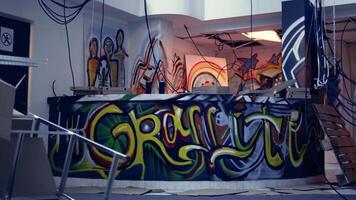 Empty derelict building with creative graffiti street art on walls, concept of alternative lifestyle. Dirty wrecked base of operations used by criminals to commit illegal activities, panning shot video