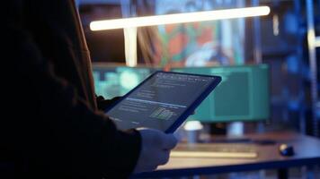 Hacker using VPN as anonymity tool to mask his online identity while committing data breaches using tablet. Cybercriminal in bunker masking his location, hacking with device, camera A close up video