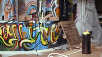 Graffiti spraying cans and empty pizza boxes in derelict building, concept of alternative lifestyle. Dolly in shot of base of operations in city slums used by criminals to commit illegal activities video