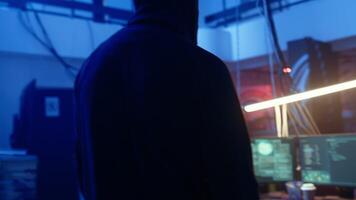Hacker arriving in underground base, ready to do computer sabotage using encryption trojan ransomware. Cybercriminal starting hacking process, ransoming stolen data from victims, camera A video