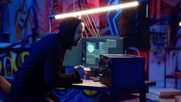 Hacker leaving secret base with suitcase full of money and stolen data obtained from victim after blackmailing with ransomware. Cybercriminal finishing criminal plan, exiting basement, camera B video