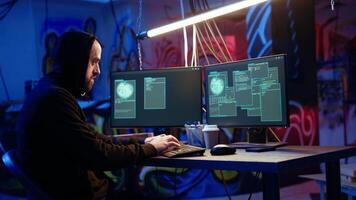 Hacker happy after successfully doing computer sabotage using encryption trojan ransomware in hidden base. Cybercriminal demands ransom money from victims after gaining access to their data, camera A video