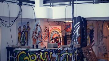 Empty industrial building with rubble and graffiti paint, concept of alternative lifestyle. Criminal hideout used by edgy teenagers to hangout and commit illegal drawing on walls, jib down and up shot video