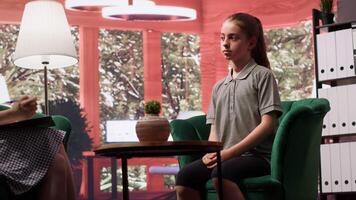 Depressed teenage girl suffering from bipolar disorder and intrusive thoughts, trying to overcome anxiety and social issues at therapy session. Counseling for the young generation. Camera A. video