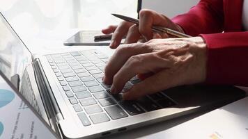 Close up hand of senior accountant using calculator and laptop for calculating finance on desk office. business financial accounting concept. video