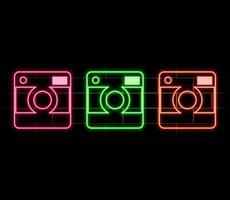 Glowing neon line Photo camera icon isolated on brick wall background. Foto camera icon. Colorful outline vector