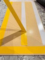 Yellow Masking Tape Application on Wooden Board for Crafting Project. High quality photo