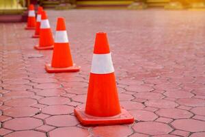 Traffic cones are placed to demarcate the boundary between the pedestrian area and the walkway. Soft and selective focus. photo